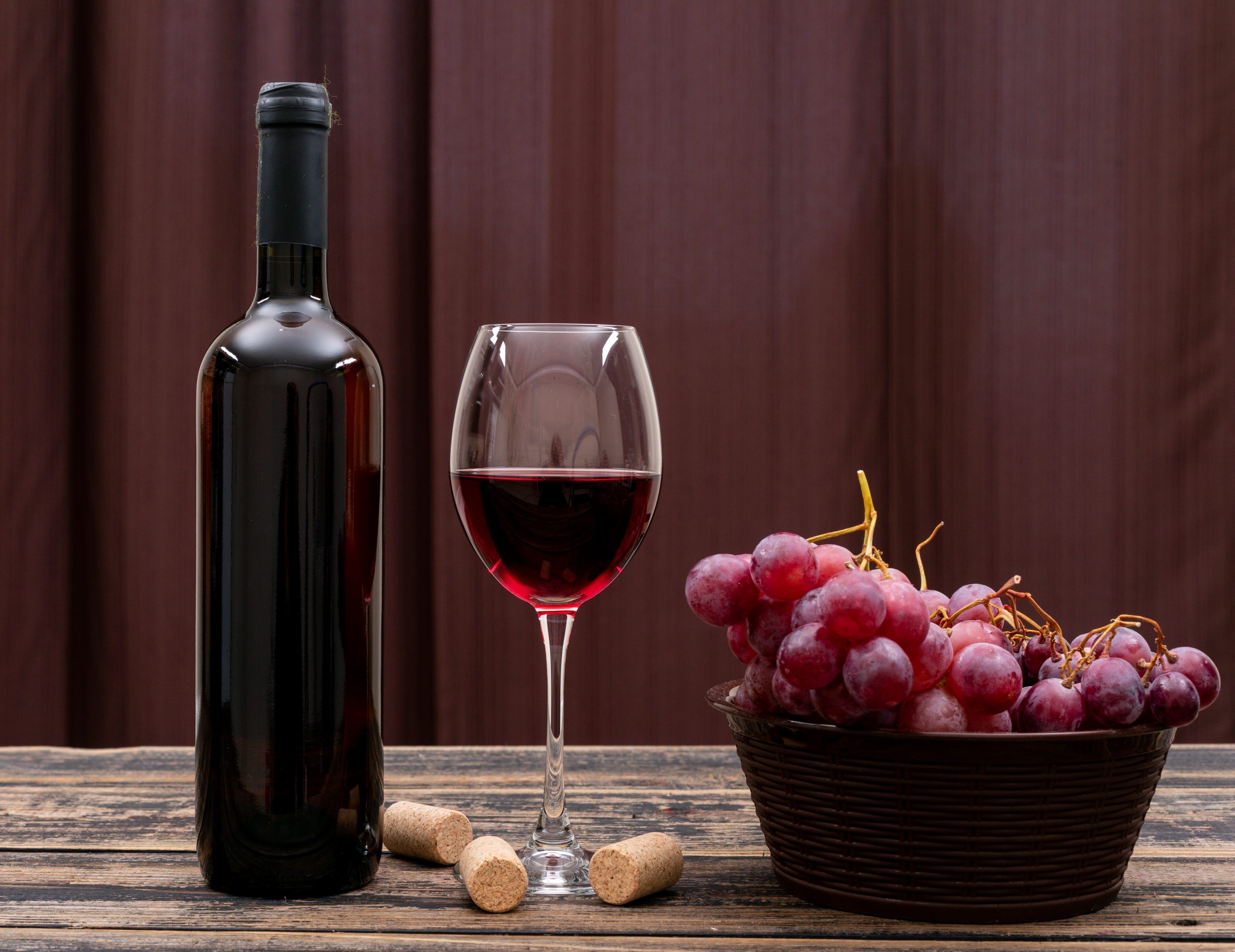 side-view-red-wine-bottle-glass-grape-dark-table-horizontal